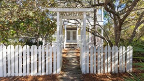 A white wooden gate leading to a covered walkway with a white picket fence on either side. - Seagrove Beach - Private Heated Pool - Bikes (Santa Rosa Beach)