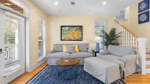 A living room with a gray sofa, yellow pillows, a round coffee table, and a blue rug. - Seagrove Beach - Private Heated Pool - Bikes (Santa Rosa Beach)