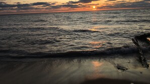 Una spiaggia con onde e un tramonto sullo sfondo.