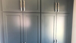 A set of dark gray cabinets with silver handles, likely part of a kitchen or storage area.