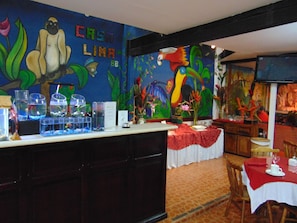 Relax in a vibrant space with a colorful mural and casual dining area featuring a bar, table, and chairs.