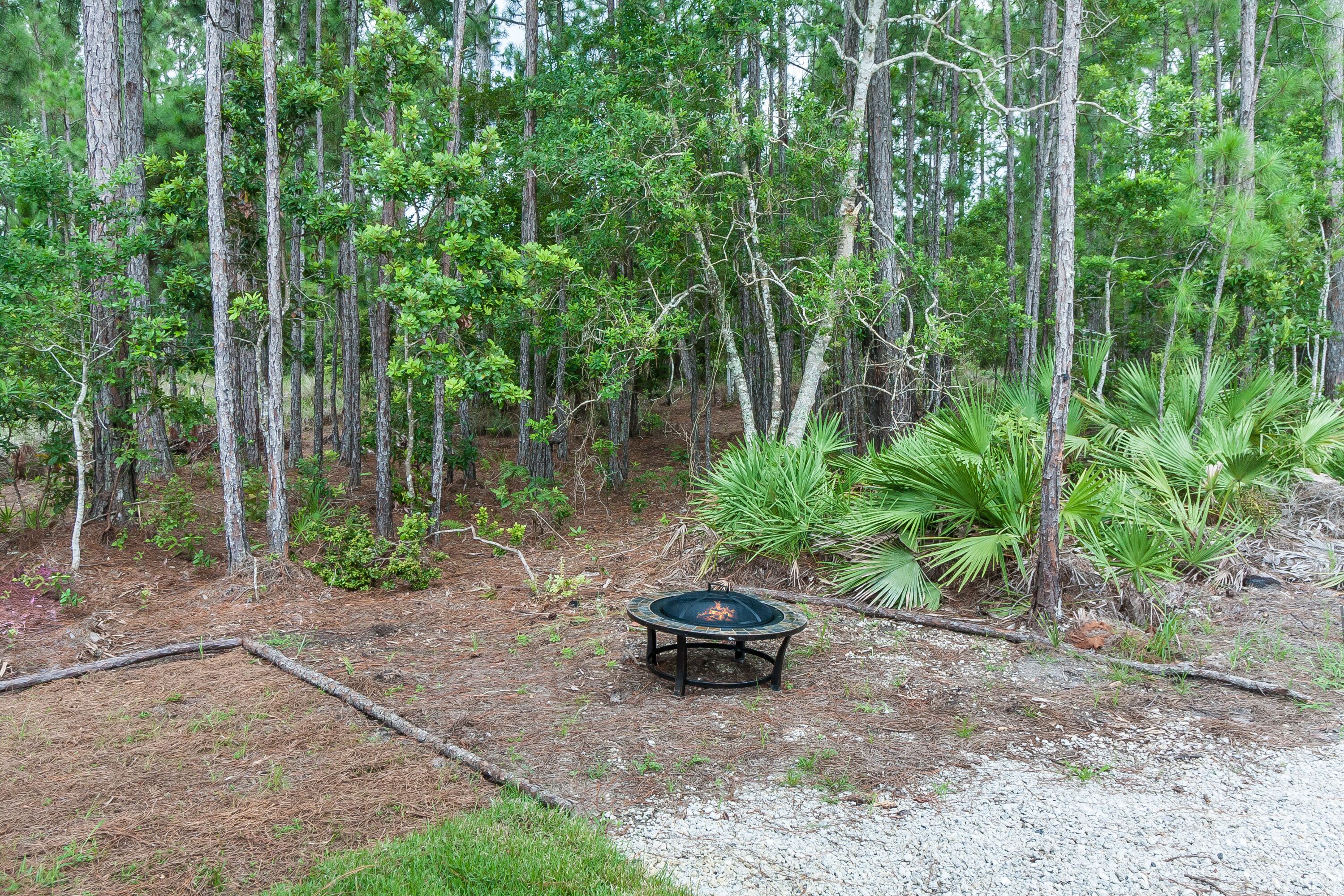 A circular outdoor seating area surrounded by dense forest.