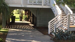 A two-story house with a covered porch and a staircase leading to the upper floor.