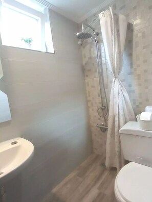 Een bad/douchecombinatie, een haardroger, een bidet, handdoeken