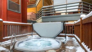 A hot tub surrounded by wooden deck and snow, with a metal railing and a wooden fence. - The Silver Cliff, 2BR Walk to Lifts and Main St! (Park City)