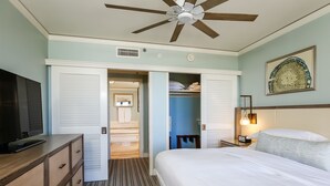 Une chambre d’hôtel équipée d’un lit, d’un bureau, d’une télévision, d’une armoire et d’un ventilateur de plafond.