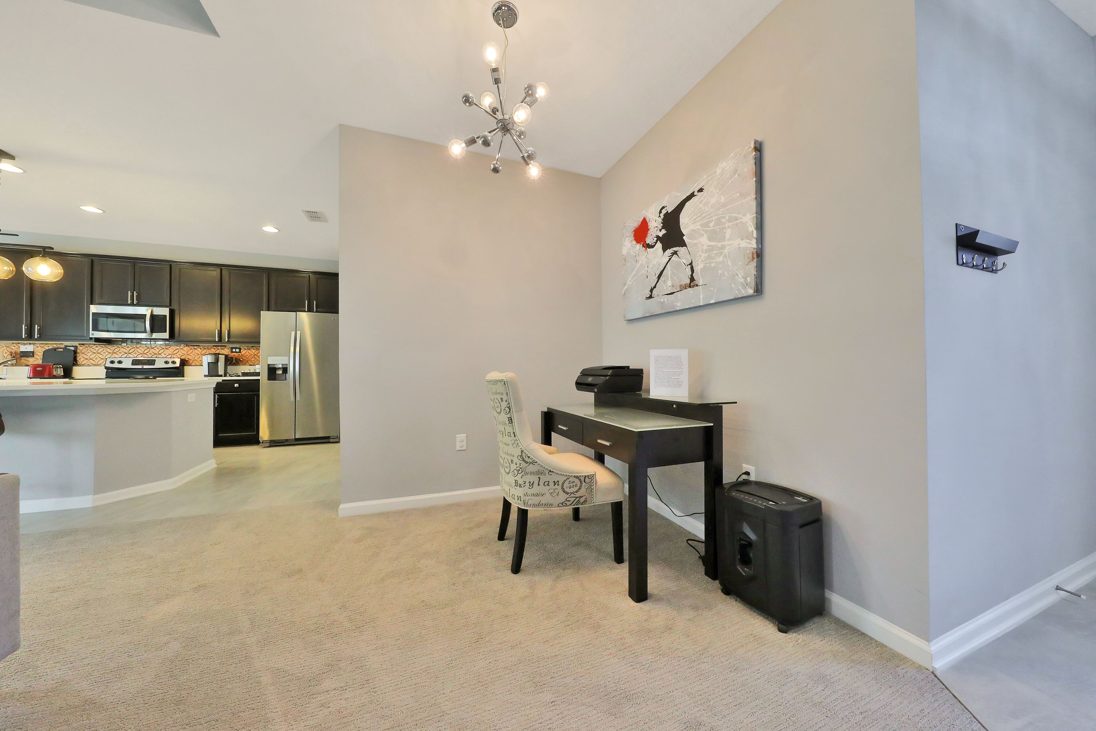 A modern kitchen with dark cabinets, stainless steel appliances, and a central island.