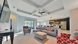 A modern living room with a sectional sofa, ottoman, and a dining table. - 3 bedroom ranch near Jax airport this charming home is set up for play or work. (Jacksonville)