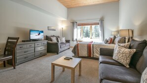 A modern living room with a television, sofa, and a small table.