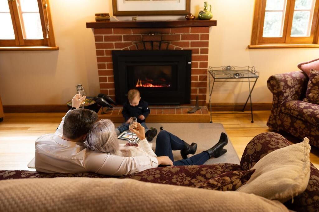 Una sala de estar acogedora con chimenea, un sofá y un niño jugando.