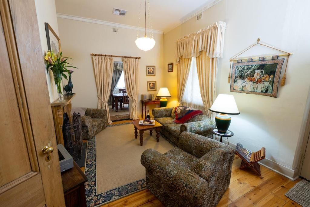 A living room with a sofa, a coffee table, a lamp, and a painting on the wall.