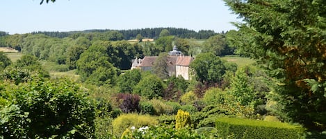 A historic building surrounded by lush greenery and a well-maintained garden.