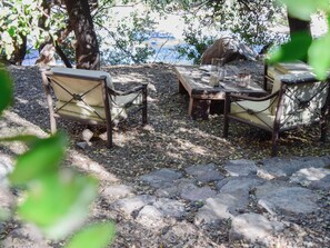 An outdoor seating area with stone flooring and wooden furniture. - Cabin between Forest and River (Lo Barnechea)