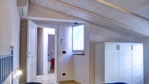 Un dormitorio con cama, armario y puerta que da a otra habitación.