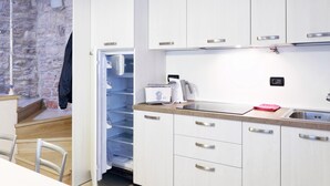 Una cocina moderna con armarios blancos, una encimera y un horno empotrado.