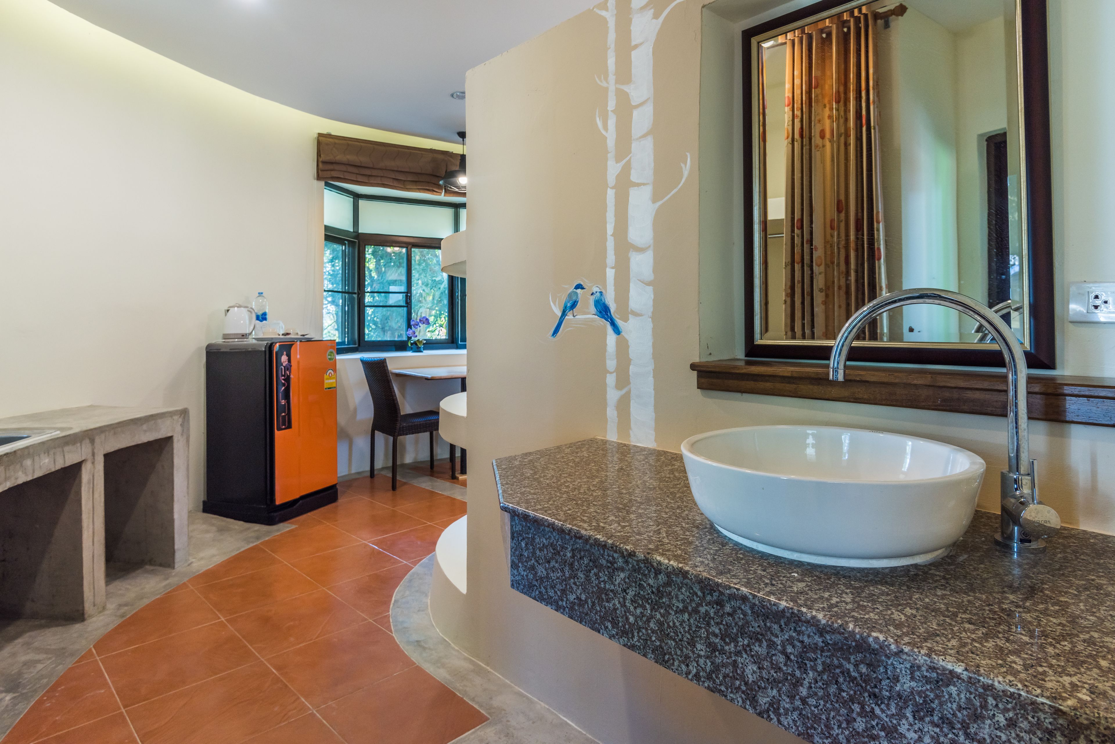 Un baño con encimera de granito, lavamanos blanco y espejo.