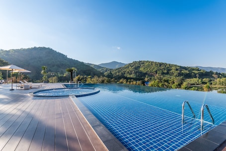 Una piscina al aire libre, sombrillas, sillones reclinables de piscina. Chiangrai Lake Hill Resort