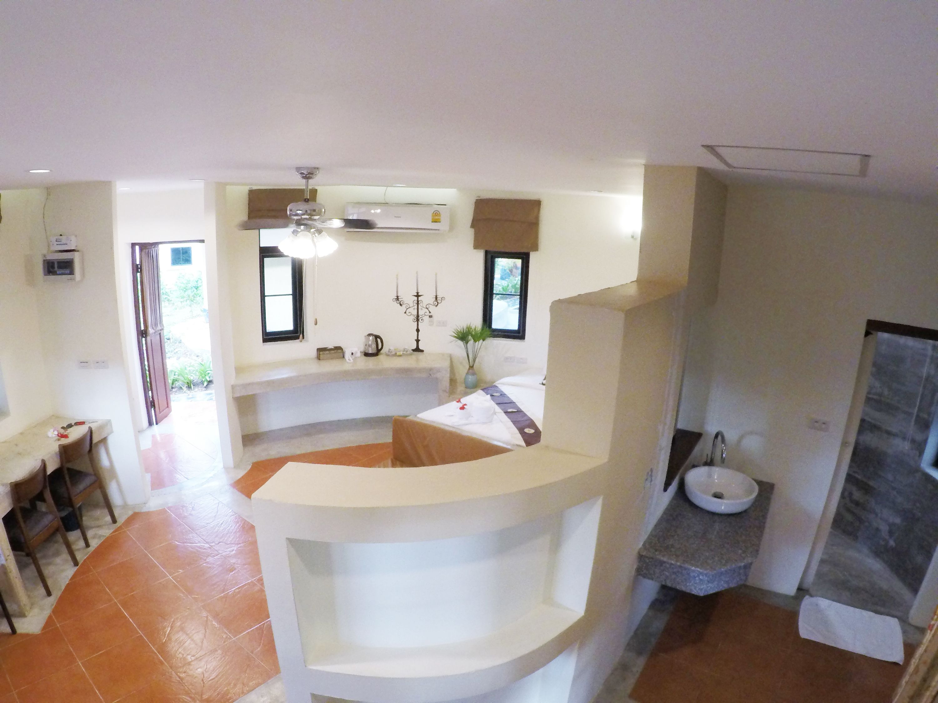 A modern kitchen with a central island, a dining area with a table and chairs, and a bathroom with a sink and toilet.