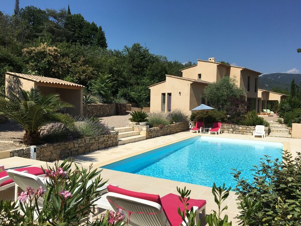 Un espace piscine avec des chaises longues et un mur en pierre.