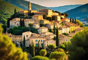 Un village historique à l’architecture traditionnelle, doté d’un clocher d’église imposant et d’une végétation luxuriante.