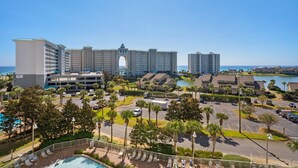 A hotel with multiple buildings, a parking lot, and a pool area.