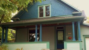 Une maison à deux étages avec un porche, une porte d’entrée et une boîte aux lettres.