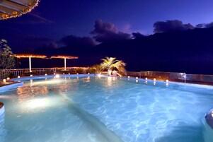 A swimming pool with a view of the mountains at night.