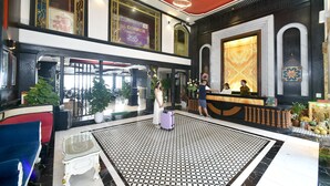 A hotel lobby with a reception desk, seating area, and a patterned floor. - Sapa Nature View Hotel (Sa Pa)