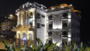A large, ornate building with multiple balconies and a grand entrance, illuminated at night. - Sapa Nature View Hotel (Sa Pa)