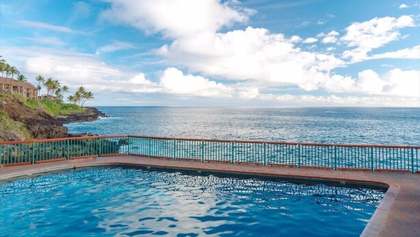 Une piscine avec vue sur l’océan et un littoral rocheux.