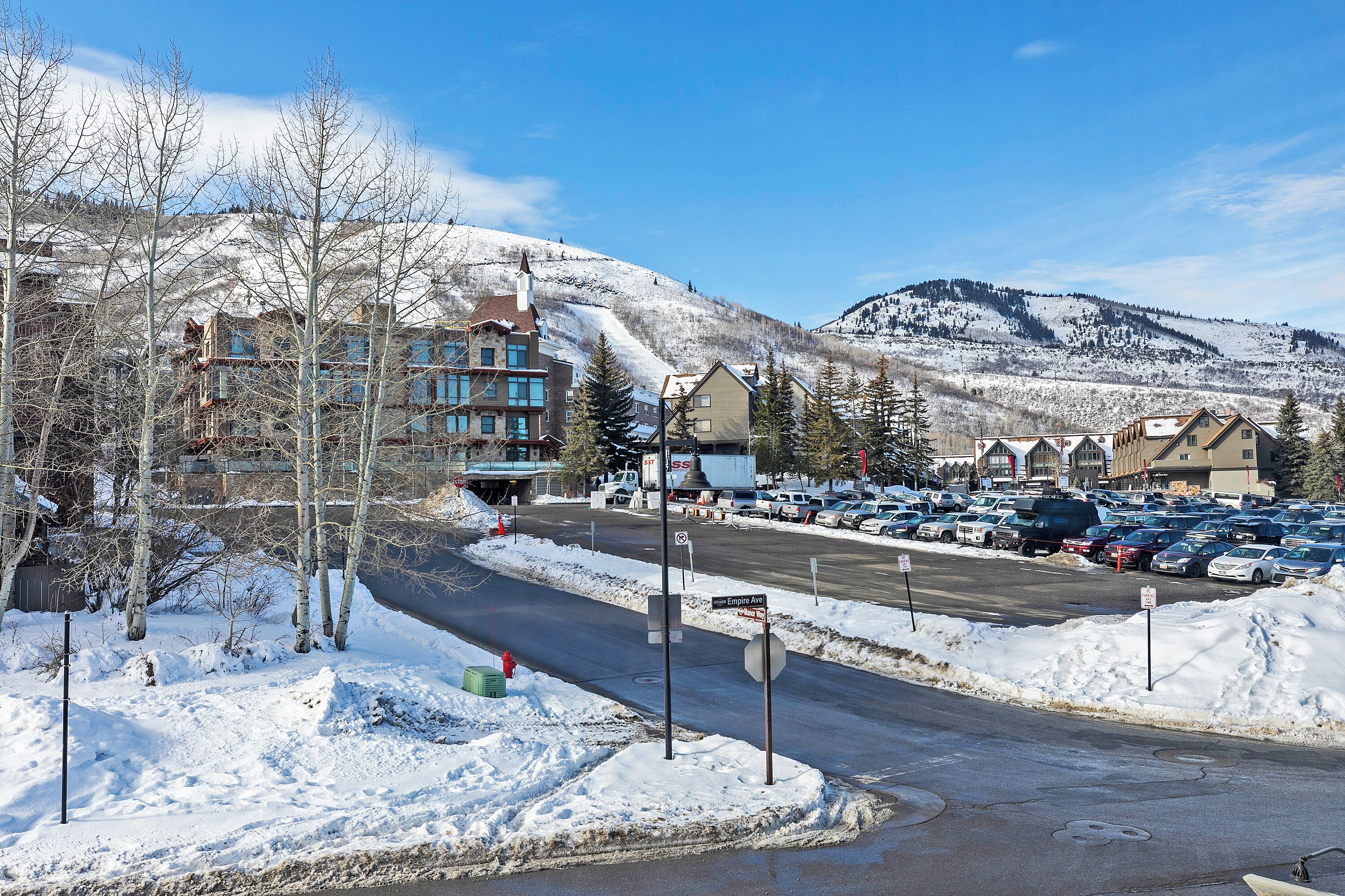 A snow-covered parking lot with buildings in the background.