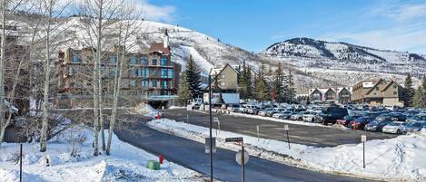 A snow-covered parking lot with buildings in the background.