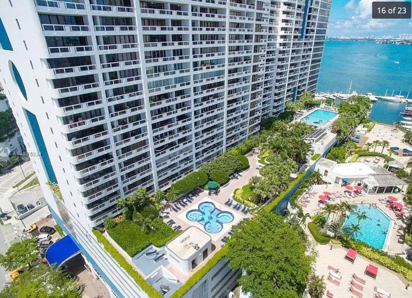 Um hotel moderno com várias varandas, piscina e vista para o mar.