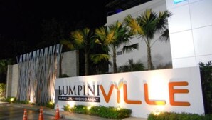 A sign for Lumpini Village with palm trees and a modern building in the background. - Lumpini Ville Pattaya Pool Gym (Pattaya)