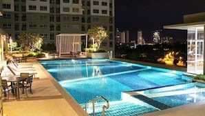 A rooftop swimming pool with a view of a city skyline at night. - Lumpini Ville Pattaya Pool Gym (Pattaya)