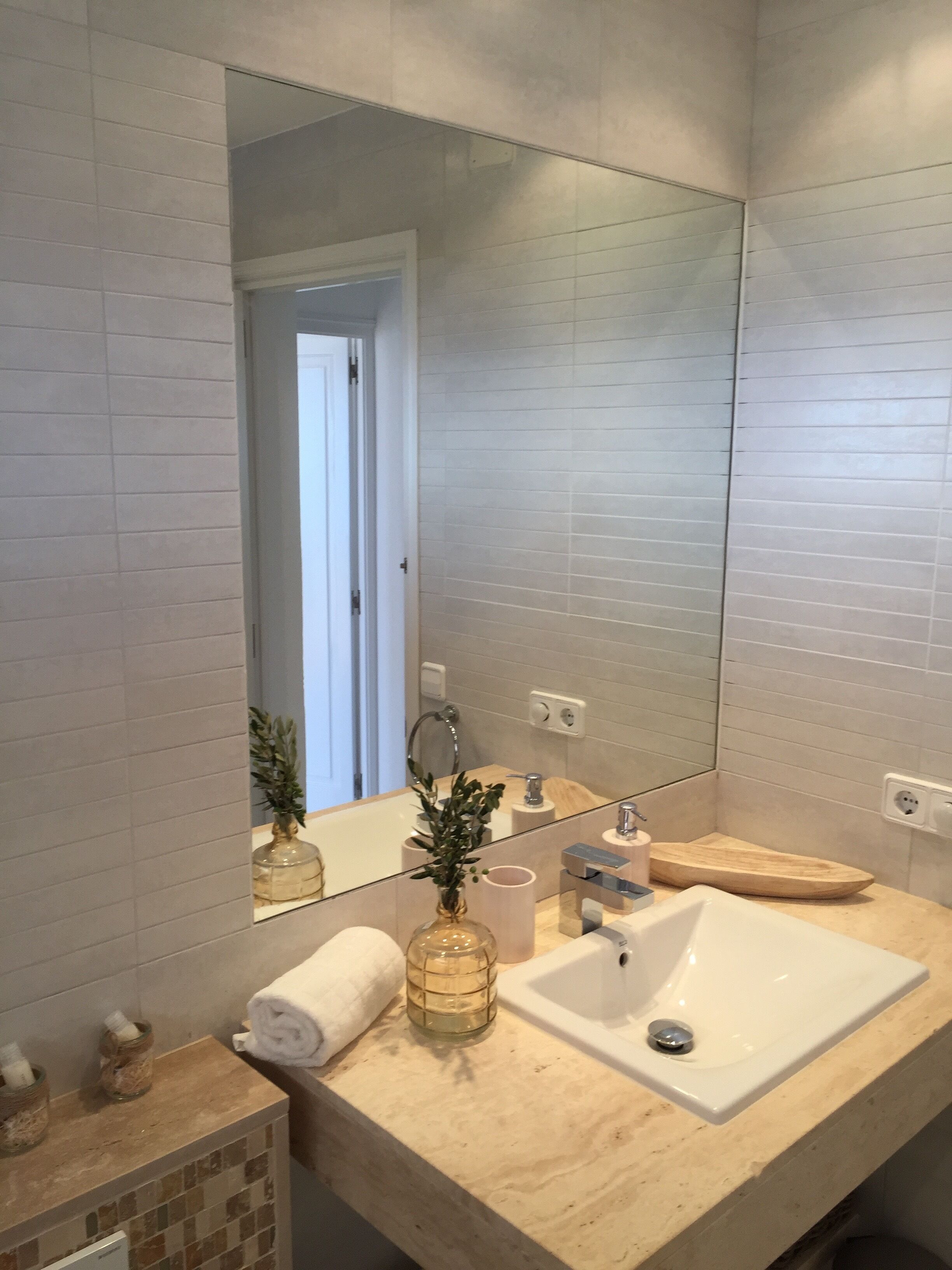 A bathroom with a white sink, a mirror, and a towel.