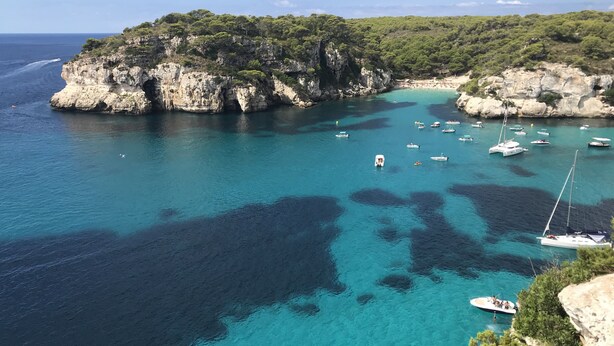 A coastal area with clear turquoise waters, rocky cliffs, and boats. - Luxury Villa, Breathtaking 180° Sea & Sunset views, Private Pool. Fully AC (San Jaime Mediterráneo, Son Bou, Menorca)