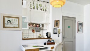 A room with a desk, chair, and a hanging light fixture.
