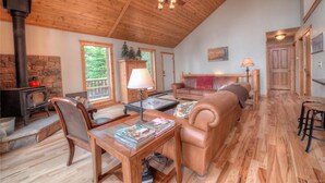A cozy living room with a stone fireplace, wooden ceiling, and a comfortable seating area. - Quiet Mountain Retreat in Valley of the Sun (Alma)