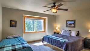 A bedroom with two beds, a ceiling fan, a window with a view of trees, and two bedside lamps. - Quiet Mountain Retreat in Valley of the Sun (Alma)