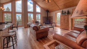 A spacious living area with a fireplace, leather sofas, and a wooden ceiling. - Quiet Mountain Retreat in Valley of the Sun (Alma)