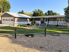 A two-story building with a garage, a covered porch, and a gravel driveway. - CANYON LAKE RETREAT
Relax, Unwind & Enjoy Lake Walks, Hiking, Kayaking & Fishing (Rapid City)