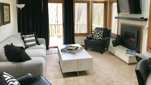 A living room with a grey sofa, a white coffee table, a black armchair, and a fireplace. - 2 Bedroom, 2 bath townhouse in The Galena Territory. (Galena)