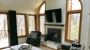 A living room with a fireplace, a television mounted above it, and a sofa with a patterned cushion. - 2 Bedroom, 2 bath townhouse in The Galena Territory. (Galena)