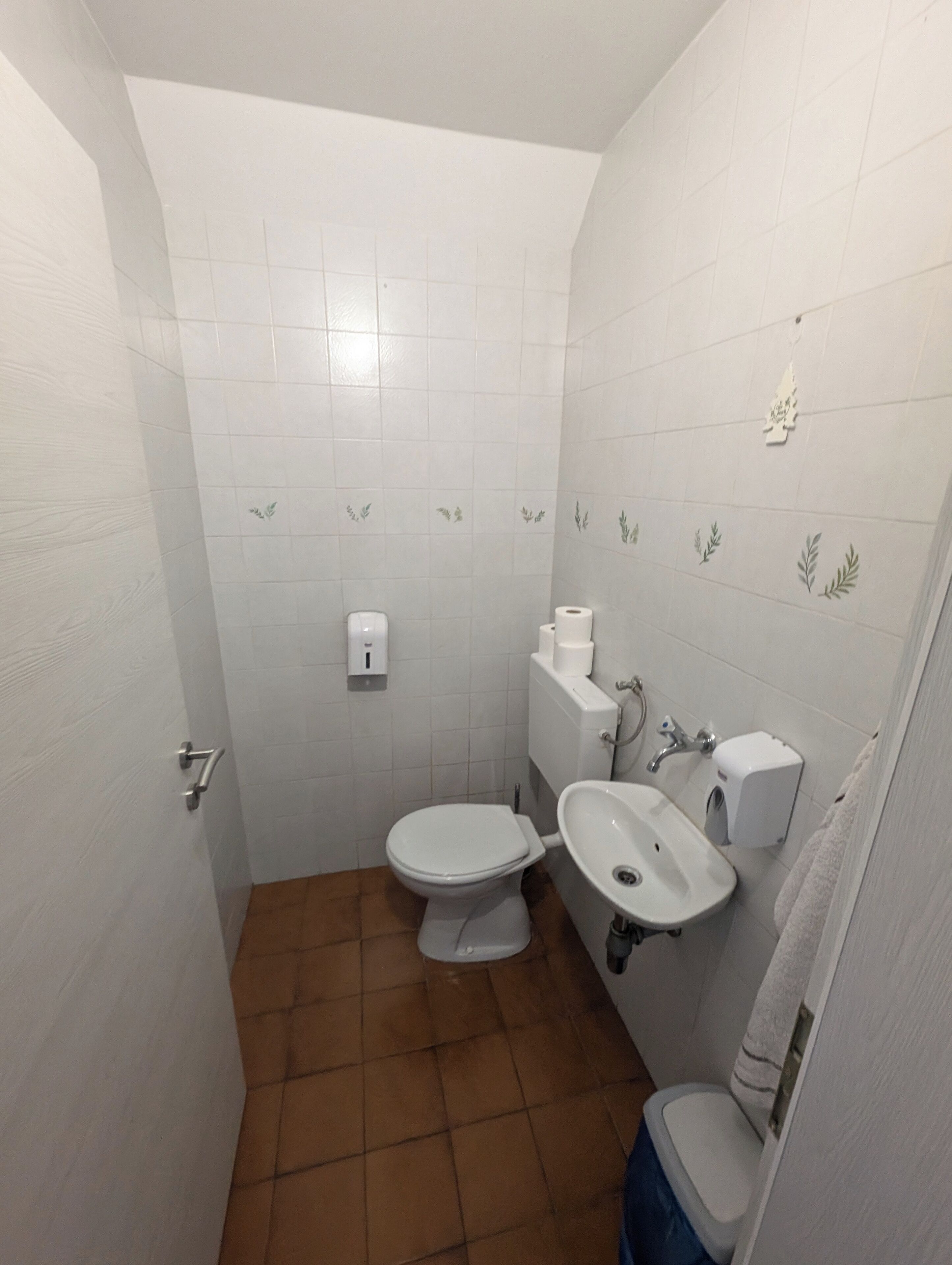 Une petite salle de bain avec des toilettes, un lavabo et un porte-serviettes.