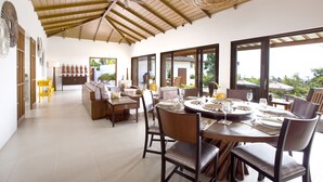 A spacious dining area with a high ceiling, wooden beams, and large windows offering a view of the outdoors. - Baan Apsara (Koh Samui)