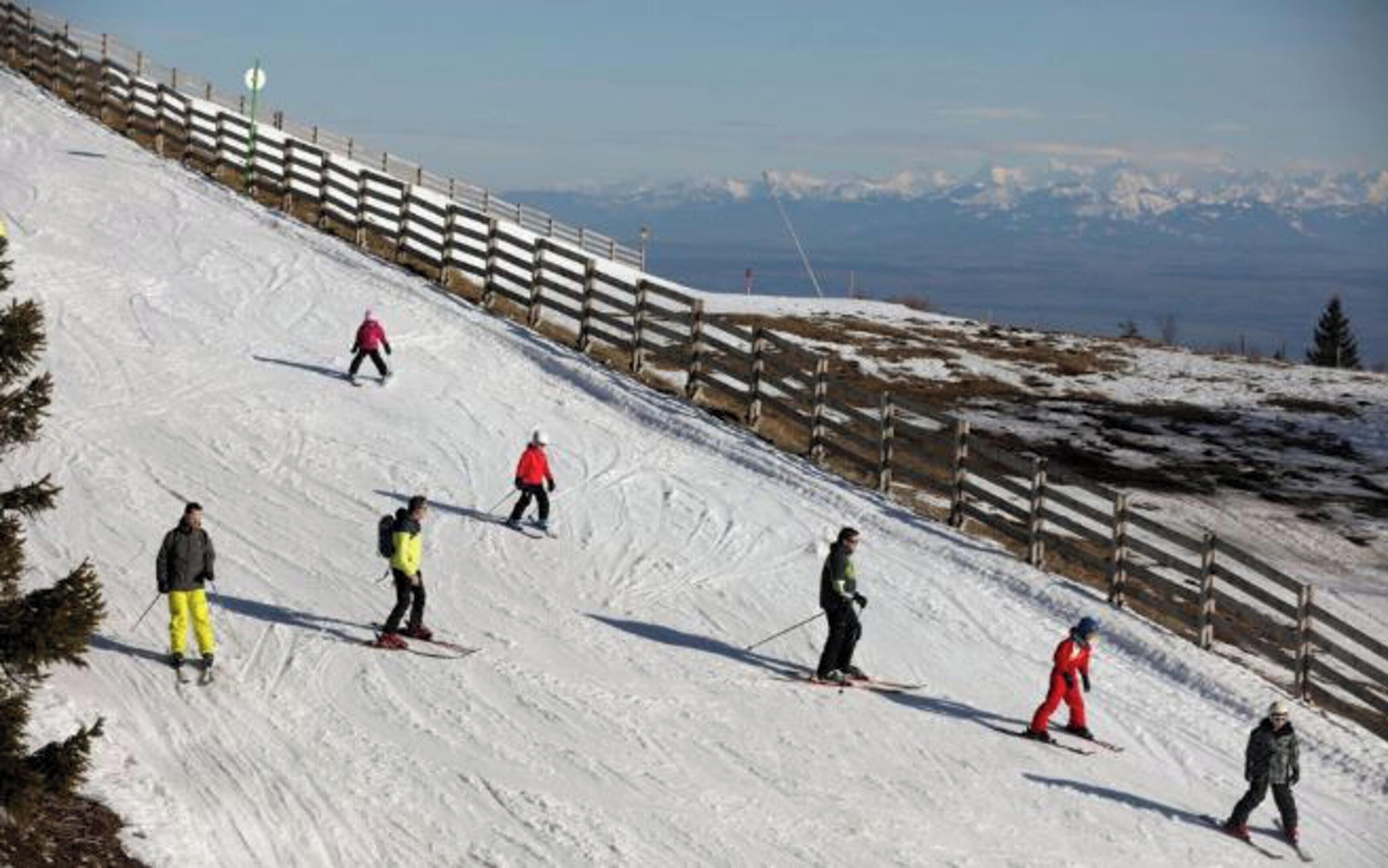 Une piste de ski avec des skieurs qui dévalent la pente.