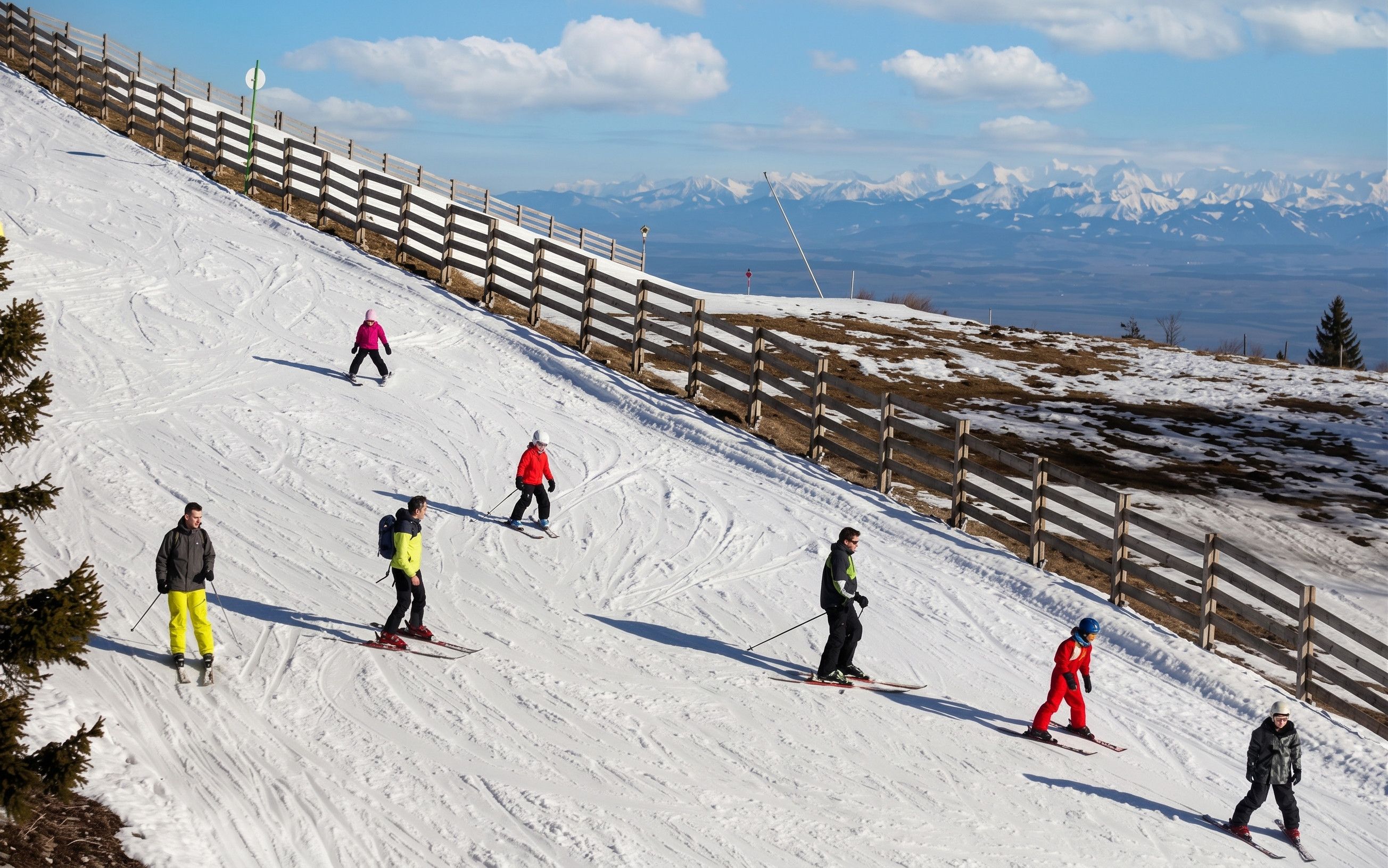 Une piste de ski avec des skieurs qui dévalent la pente.