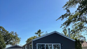 Une maison de plain-pied avec un patio couvert, un garage et une pelouse.