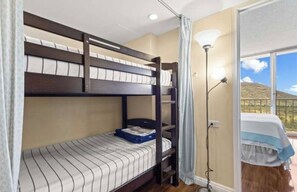 A bunk bed room with a window and a lamp. - Panoramic Ocean/Mountain View Apartment  (Mākaha)